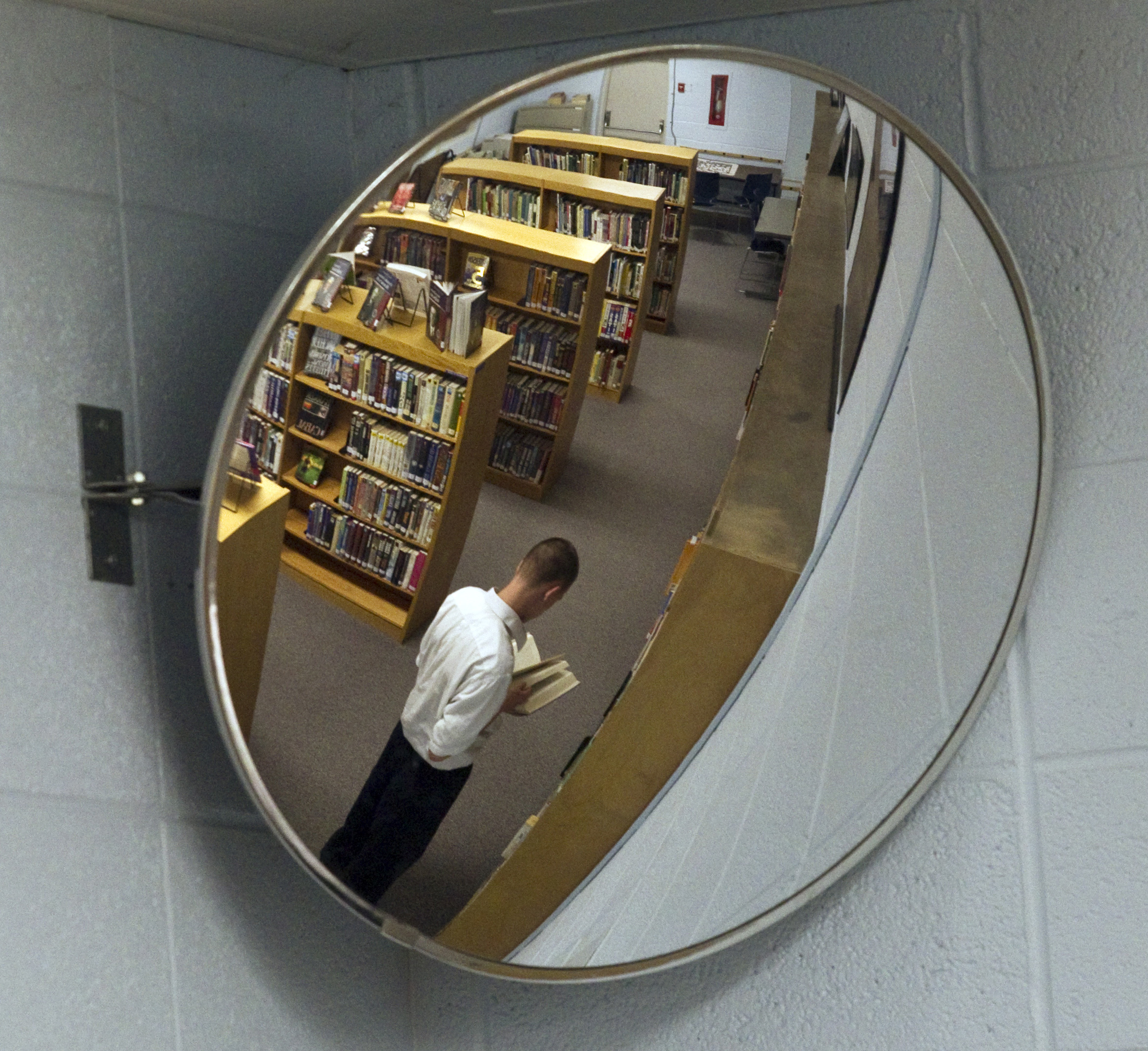 In this May 20, 2010 photo, a youth is seen in a mirror in the library at the Wisconsin Department of Corrections Ethan Allen School Thursday, May 20, 2010, in Wales, Wis. States across the country are shutting down dozens of youth prisons like Ethan Allen School.