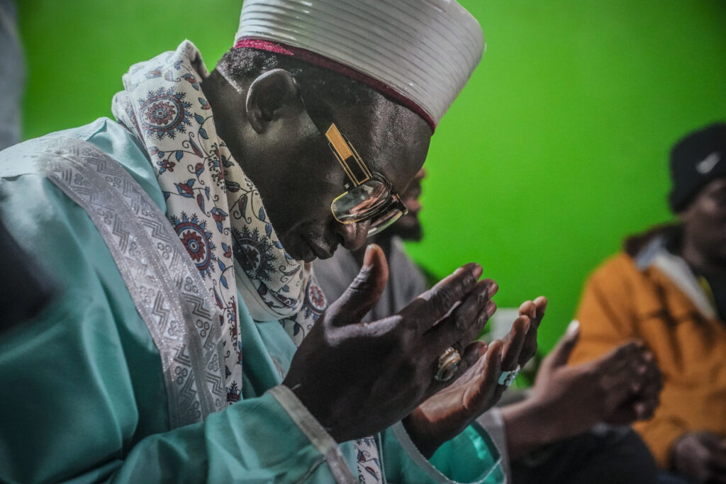 Imam Omar Niass leads evening prayers with mostly Senegalese migrants, before the breaking of Ramadan fast and the serving of a festive meal called an iftar, Friday March 15, 2024, at Bronx's Masjid Ansaru-Deen mosque in New York.