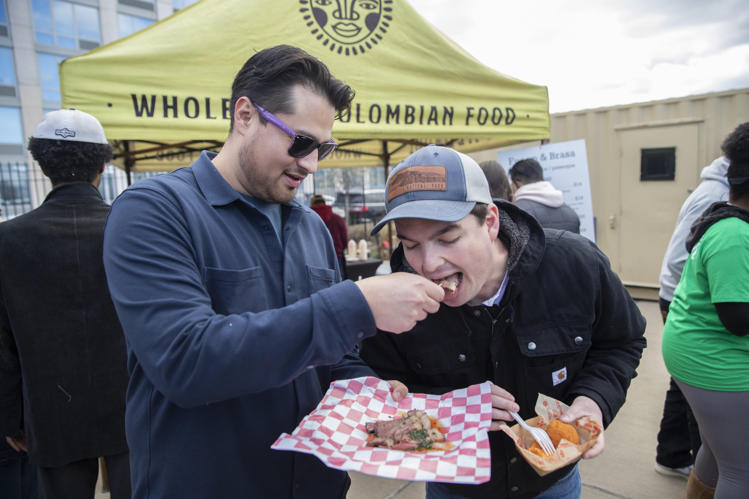 Marlon Gonzalez lets Jack Murray try a bite of his food at Williamsburg Smorgasburg.