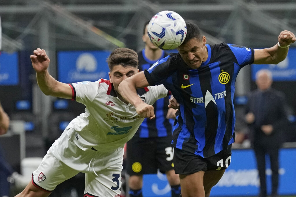 Inter Milan's Alexis Sanchez, right, heads the ball during the Italian Serie A soccer match between Inter Milan and Cagliari at the San Siro stadium in Milan, Italy, Sunday, April 14, 2024. (AP Photo/Antonio Calanni)
