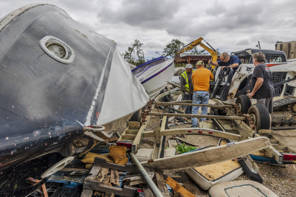 Volunteers and staff of Scotty's Performance Boat & Marine attempt to salvage boats on Thursday, April 11, 2024, in Slidell, La., after a tornado hit a day earlier. (Chris Granger/The Times-Picayune/The New Orleans Advocate via AP)
