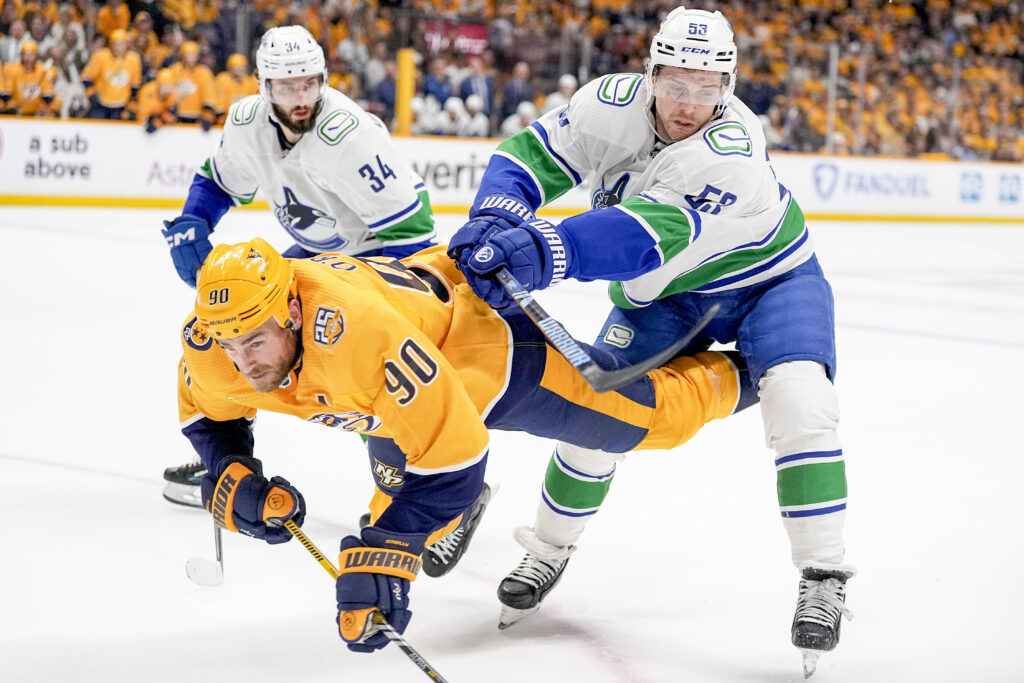 Vancouver Canucks center Teddy Blueger (53) hits Nashville Predators center Ryan O'Reilly (90) to the ice during the second period in Game 4 of an NHL hockey Stanley Cup first-round playoff series Sunday, April 28, 2024, in Nashville, Tenn. (AP Photo/George Walker IV)