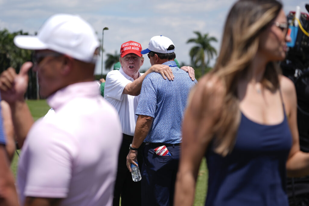 Republican presidential candidate former President Donald Trump, center left, greets people as he visits the driving range ahead of the final round of LIV Golf Miami, at Trump National Doral Golf Club, Sunday, April 7, 2024, in Doral, Fla. (AP Photo/Rebecca Blackwell)