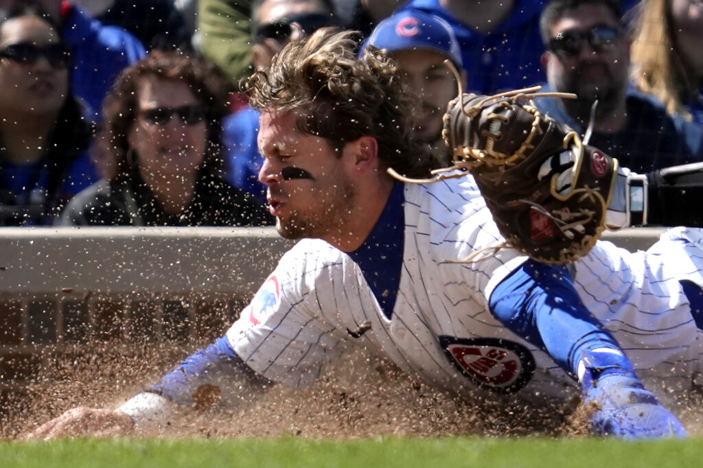 Chicago Cubs' Nico Hoerner is tagged out by Miami Marlins catcher Nick Fortes at home during the fourth inning of a baseball game in Chicago, Sunday, April 21, 2024. (AP Photo/Nam Y. Huh)