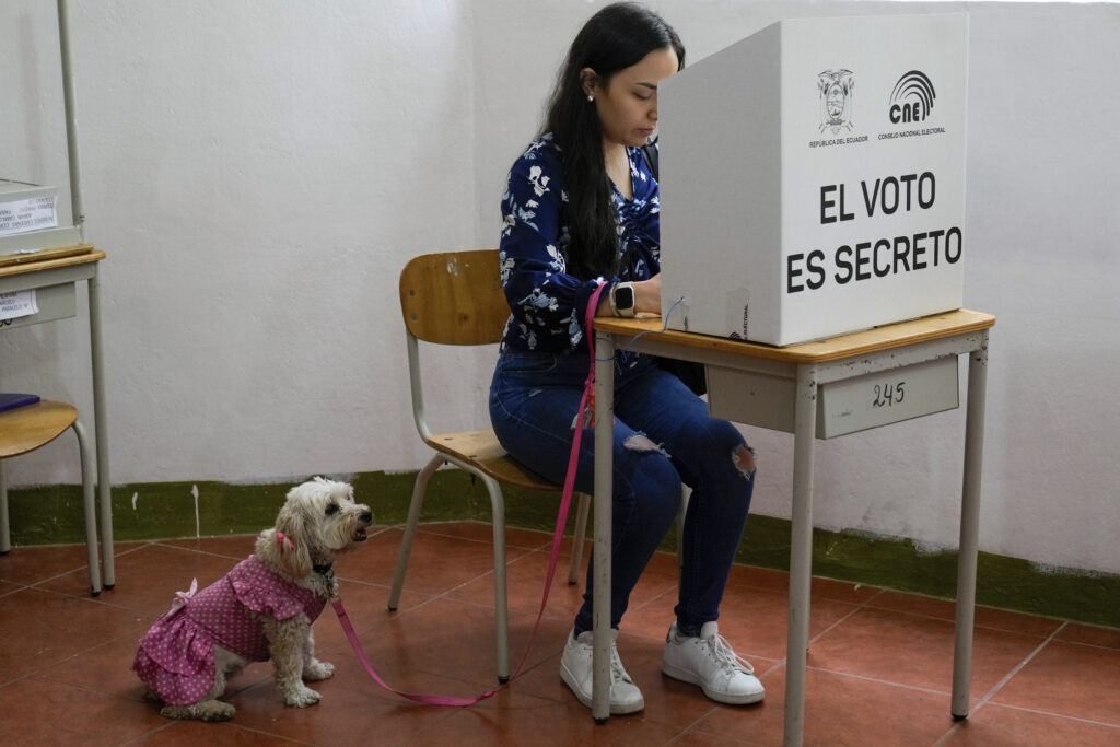 A voter marks questions on the ballot of a referendum proposed by President Daniel Noboa to endorse new security measures aimed at crack down on criminal gangs fueling escalating violence in Quito, Ecuador, Sunday, April 21, 2024. (AP Photo/Dolores Ochoa)