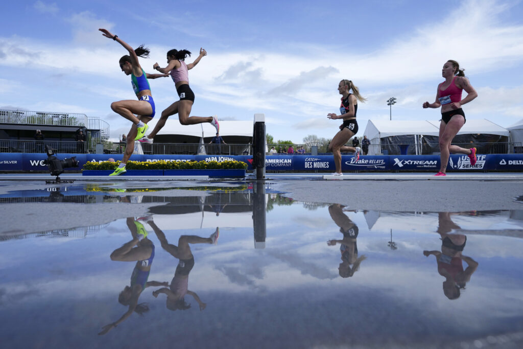 Runners in the women's invitational 3,000-meter steeplechase leap over the water pit at the Drake Relays athletics meet, Saturday, April 27, 2024, in Des Moines, Iowa. (AP Photo/Charlie Neibergall)