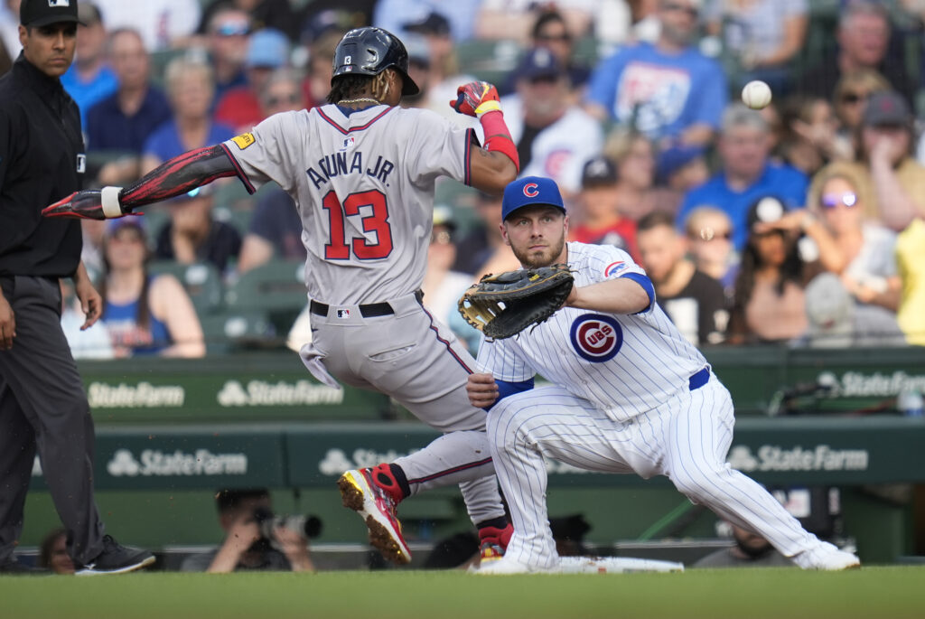 Chicago Cubs starting pitcher Javier Assad throws to first baseman Michael Busch trying to force out Atlanta Braves' Ronald Acuña Jr. during the first inning of a baseball game Tuesday, May 21, 2024, in Chicago. (AP Photo/Erin Hooley)
