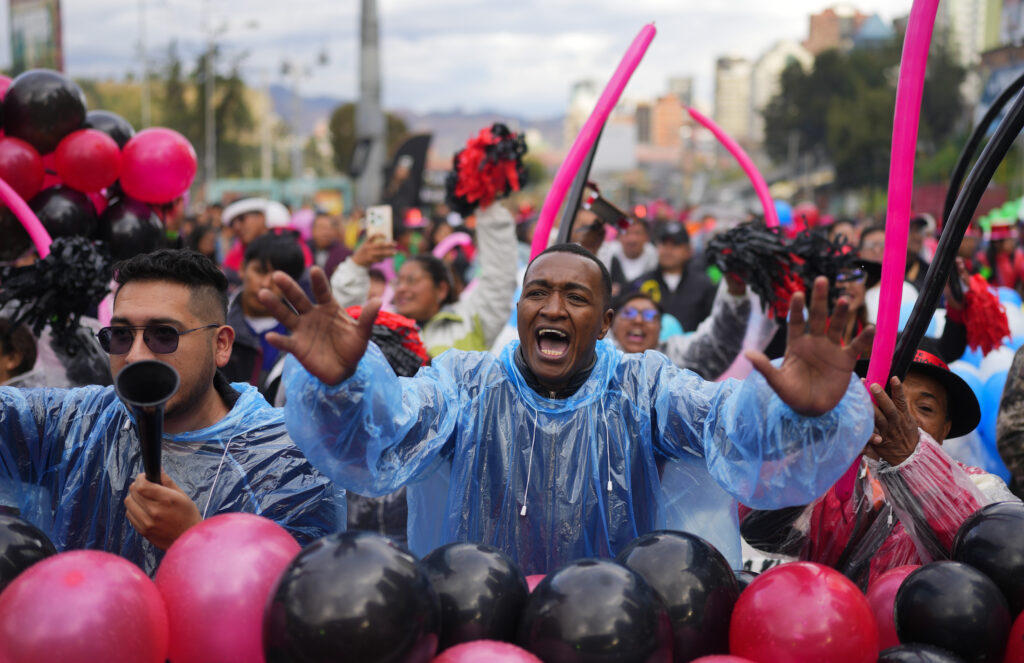 People cheer for their favorite contestant during the Queen of Great Power contest, in La Paz, Bolivia, Wednesday, May 1, 2024. The contest takes place ahead of the Festival of the Lord Jesus of Great Power, a street party that celebrates a rendering of Jesus Christ with native features and outstretched arms. (AP Photo/Juan Karita)