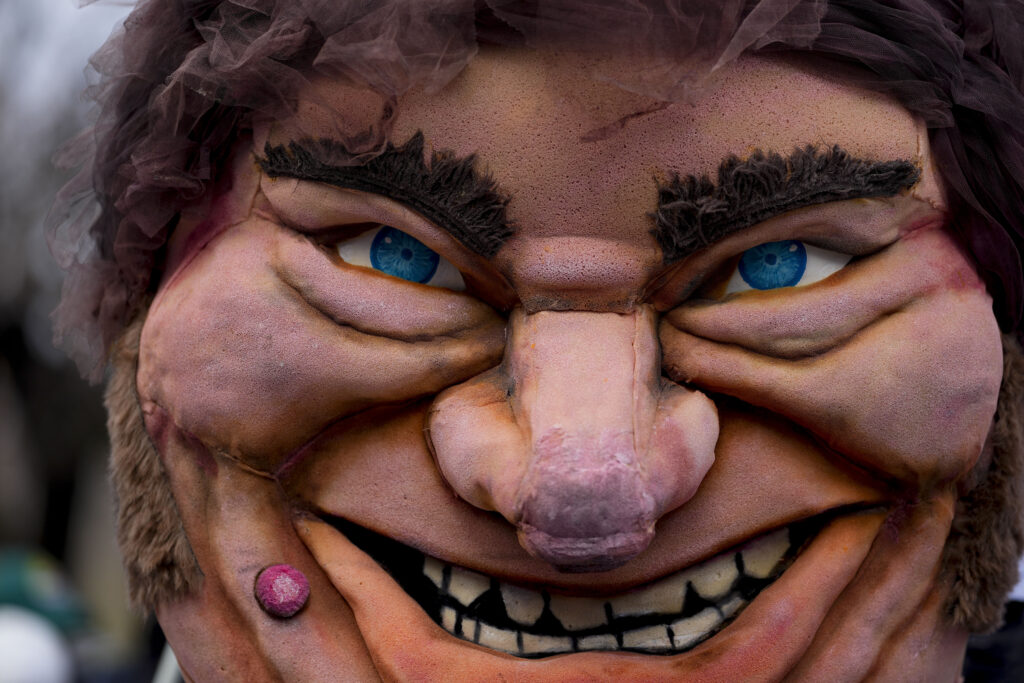 A large puppet of Argentine President Javier Milei is held by a protester outside a government depot for food storage where people gather to demand the release of supplies for soup kitchens, which depend on the government for some of their food supply, in Buenos Aires, Argentina, Wednesday, May 29, 2024. (AP Photo/Natacha Pisarenko)