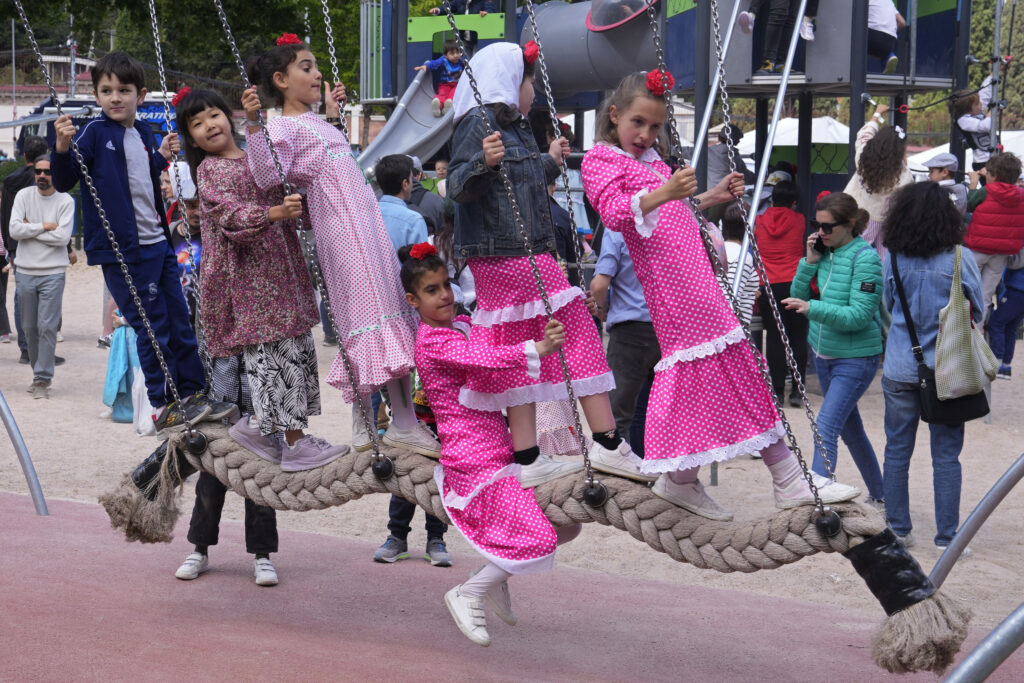 Children wearing regional 'Chulapa' dress play on a swing during the San Isidro festivities in Madrid, Spain, Wednesday May 15, 2024. The festivities during the bank holiday are in honour of the patron saint of Madrid. (AP Photo/Paul White)