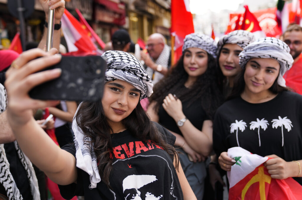 Supporters of the Lebanese Communist party take a selfie, as they march during a demonstration to mark International Labor Day or May Day, in Beirut, Wednesday, May 1, 2024. Despite the tense situation and ongoing clashes on Lebanon's border with Israel over the past seven months, hundreds of protesters marched through Beirut's streets to mark International Workers' Day. (AP Photo/Hussein Malla)