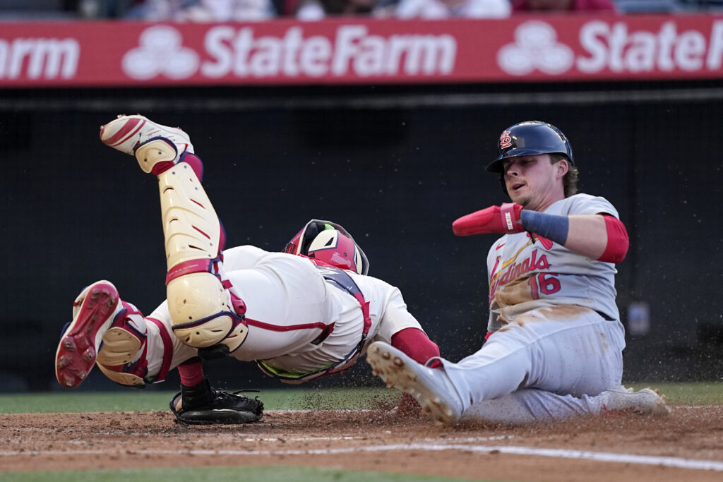 St. Louis Cardinals' Nolan Gorman, right, scores after Michael Siani hit into a fielder's choice as Los Angeles Angels catcher Logan O'Hoppe dives after an errant throw to home during the second inning of a baseball game Tuesday, May 14, 2024, in Anaheim, Calif. (AP Photo/Mark J. Terrill)