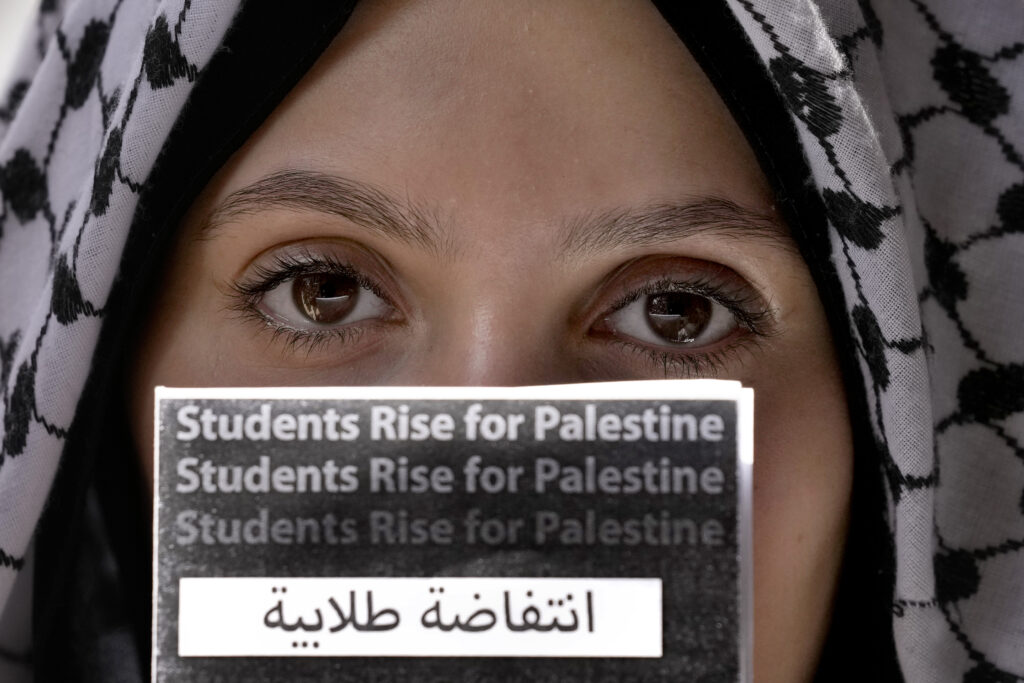 A student holds a placard during a protest inside the American University of Beirut to show support for Palestinians in the Gaza Strip, in Beirut, Lebanon, Tuesday, May 7, 2024. The protesting university students demanded an end to Israel's war in Gaza and its continued attacks in Lebanon, as well as the American University of Beirut to end economic ties with companies that they say are "complicit in the Israeli occupation of Palestinians." (AP Photo/Bilal Hussein)