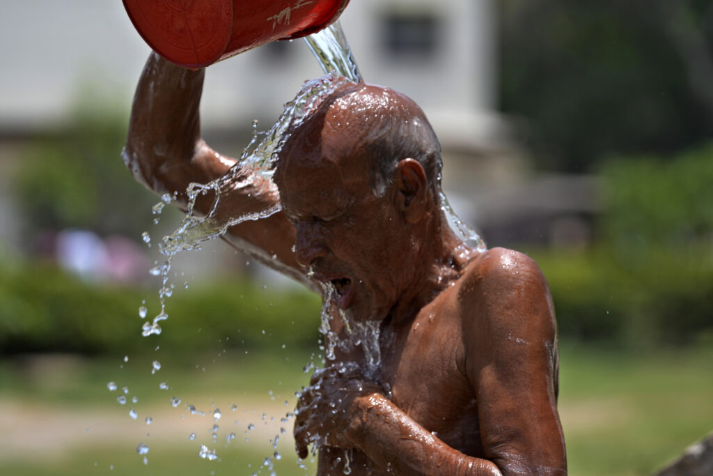 A man cools off himself during a hot summer day at a park in Karachi, Pakistan, Tuesday, May 21, 2024. Authorities in Pakistan on Tuesday urged people to stay indoors as the country is hit by an extreme heat wave that threatens to bring dangerously high temperatures and yet another round of glacial-driven floods. (AP Photo/Fareed Khan)