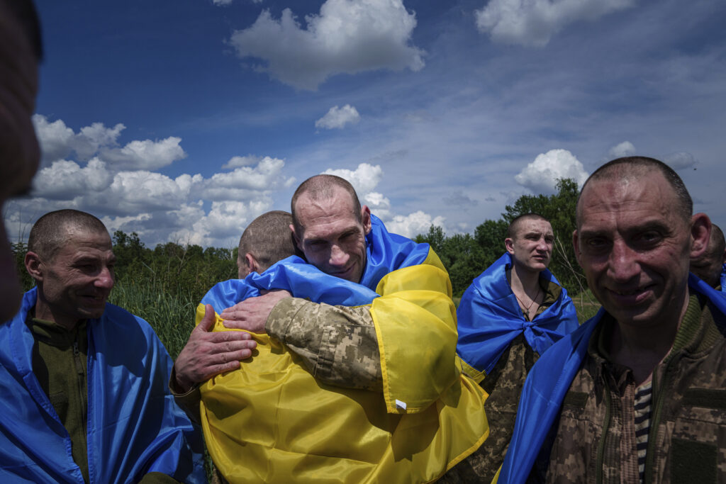 A Ukrainian serviceman hugs his comrade after returning from captivity during a POWs exchange in Sumy region, Ukraine, Friday, May 31, 2024. Ukraine returned 75 prisoners, including four civilians, in the latest exchange of POWs with Russia. It's the fourth prisoner swap this year, and 52nd since Russia invaded Ukraine. In all, 3 210 Ukrainian servicemen and civilians were returned since the outbreak of the war. (AP Photo/Evgeniy Maloletka)
