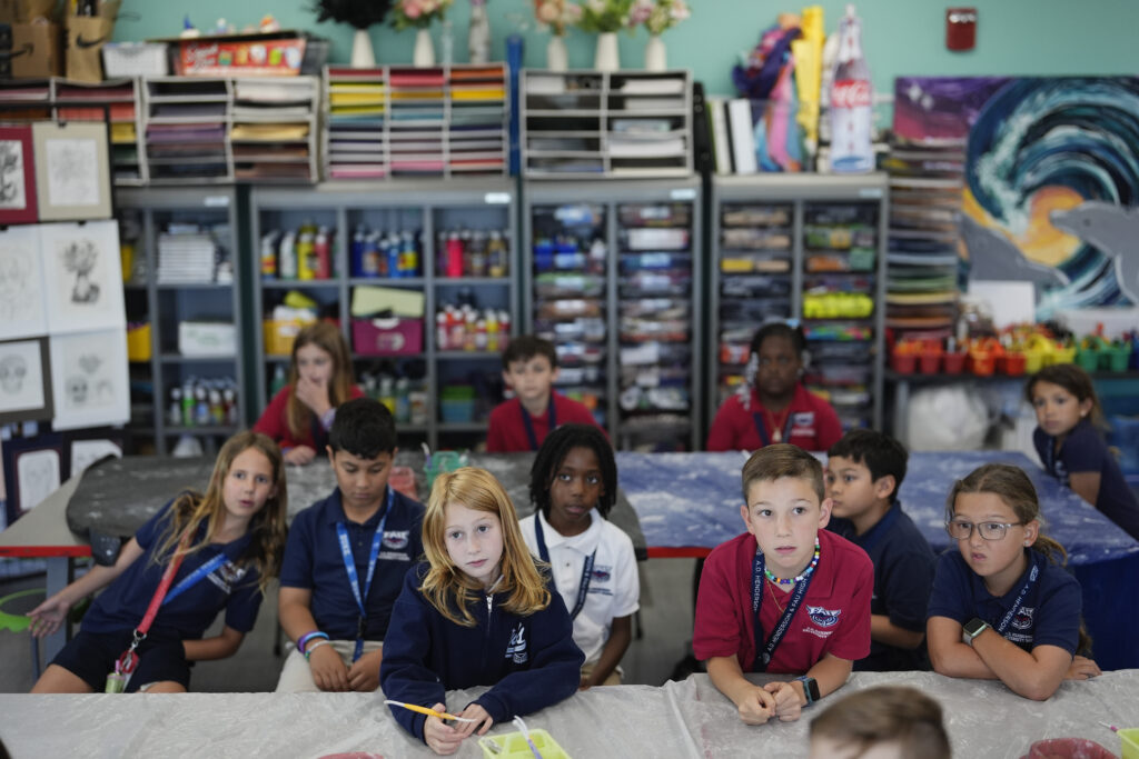 Third graders listen at the start of Lindsey Wuest's Science As Art class, at A.D. Henderson School in Boca Raton, Fla., Tuesday, April 16, 2024. When teachers at the K-8 public school, one of the top-performing schools in Florida, are asked how they succeed, one answer is universal: They have autonomy. (AP Photo/Rebecca Blackwell)