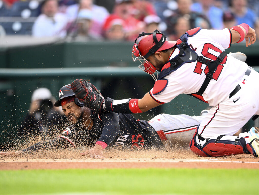 Minnesota Twins' Byron Buxton, left, is tagged out by Washington Nationals catcher Keibert Ruiz (20) on a double by Twins' Willi Castro during the second inning of a baseball game, Monday, May 20, 2024, in Washington. (AP Photo/Nick Wass)