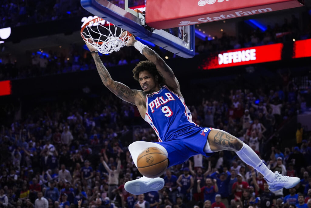 Philadelphia 76ers' Kelly Oubre Jr. hangs from the rim after dunking against the New York Knicks during the second half of Game 6 in an NBA basketball first-round playoff series Thursday, May 2, 2024, in Philadelphia. (AP Photo/Matt Slocum)