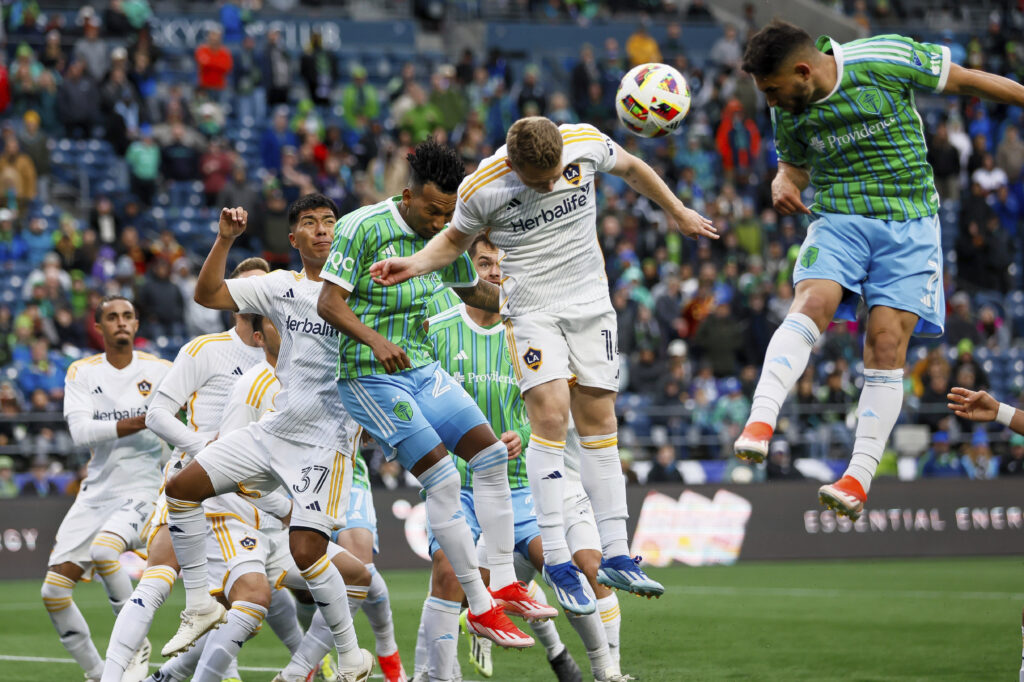 Seattle Sounders FC midfielders Léo Chú, left, and Cristian Roldan, far right, try to get on the end of a corner kick against Los Angeles Galaxy midfielder Daniel Aguirre (37) and defender John Nelson during the second half of an MLS soccer match, Sunday, May 5, 2024, in Seattle. (Jennifer Buchanan/The Seattle Times via AP)