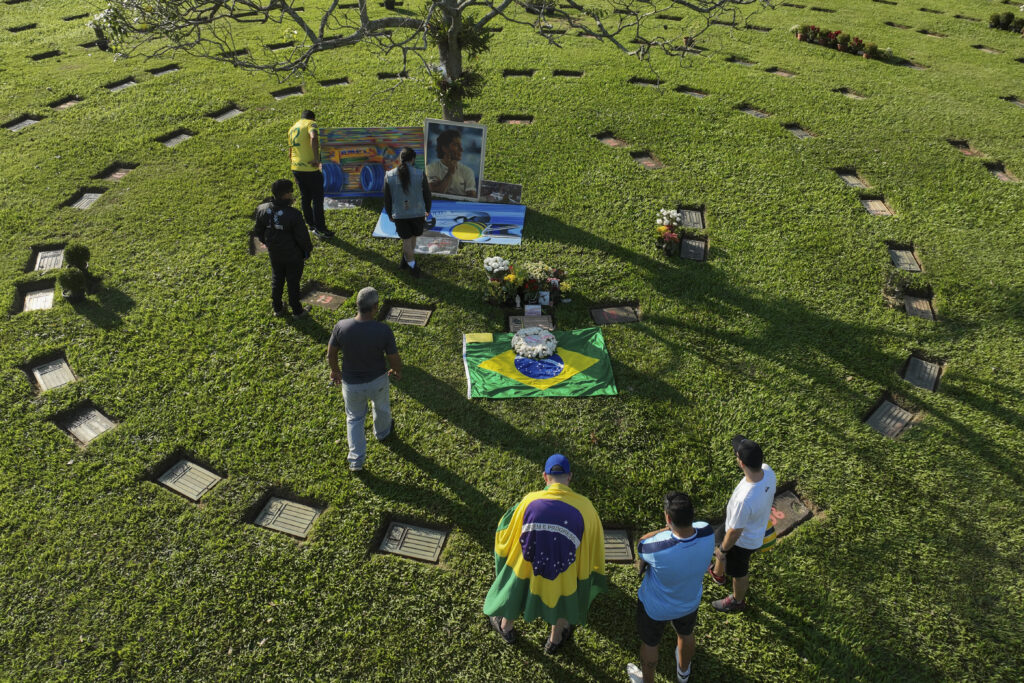 Fans gather at the burial site of late Brazilian Formula One driver Ayrton Senna to mark the 30th anniversary of his death, at Morumbi cemetery in Sao Paulo, Brazil, Wednesday, May 1, 2024. The three-time F1 world champion died in a crash at the Imola race track in San Marino. (AP Photo/Andre Penner)