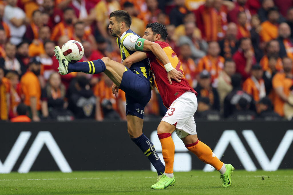 Fenerbahce's Dusan Tadic, left, fights for the ball with Galatasaray's Kaan Ayhan, during a Turkish Super Lig soccer match between Galatasaray and Fenerbahce in Istanbul, Turkey, Sunday, May 19, 2024. (AP Photo)