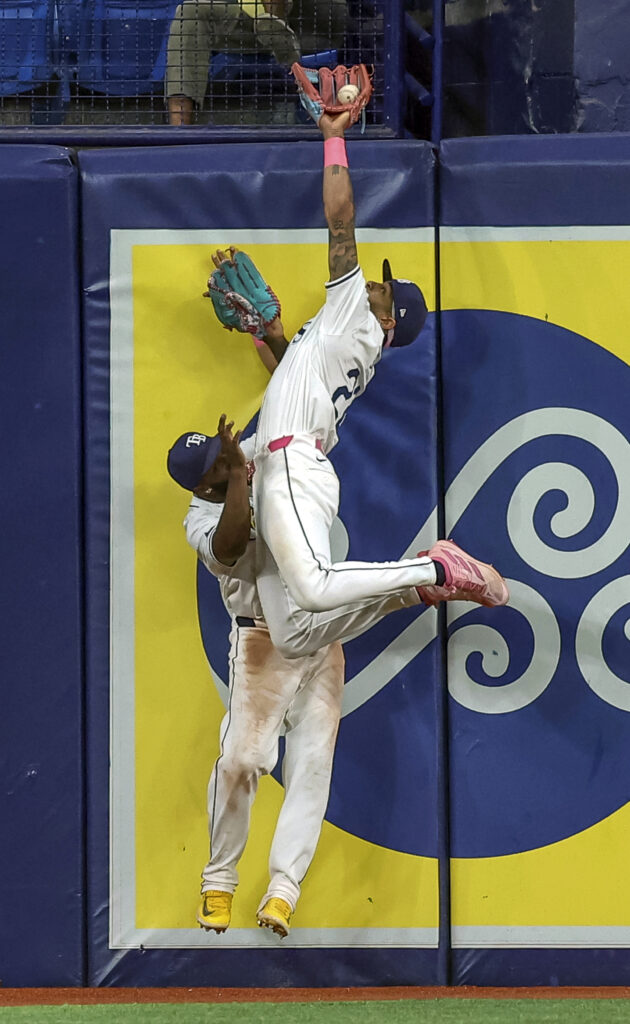 Tampa Bay Rays' Jose Siri makes a catch on a fly ball from Oakland Athletics' Zack Gelof as he collides with Randy Arozarena during the ninth inning of a baseball game Wednesday, May 29, 2024, in St. Petersburg, Fla. (AP Photo/Mike Carlson)