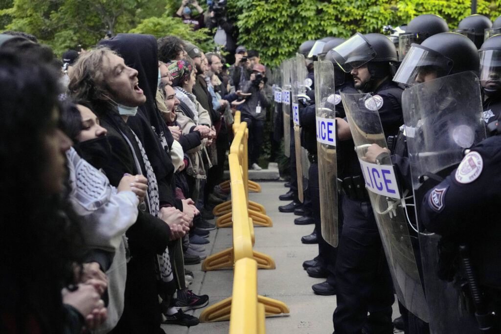 Pro-Palestinian protesters chant at University of Chicago police while being kept from the university's quad as the student encampment is dismantled Tuesday, May 7, 2024, in Chicago. (AP Photo/Charles Rex Arbogast)