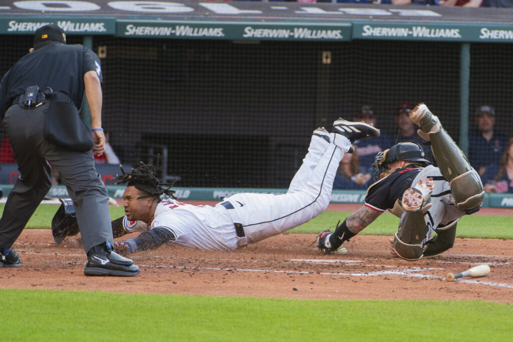 Minnesota Twins' Christian Vazquez, right, tags out Cleveland Guardians' Jose Ramírez at home as umpire Alfonso Marquez, left, watches during the third inning of a baseball game in Cleveland, Saturday, May 18, 2024. (AP Photo/Phil Long)