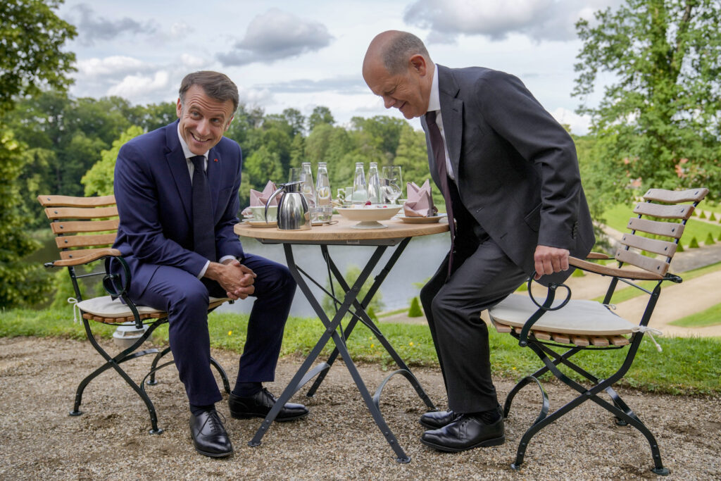German Chancellor Olaf Scholz, right, and French President Emmanuel Macron sit at a table in the garden of the German government guest house in Meseberg, north of Berlin, Germany, Tuesday, May 28, 2024. (AP Photo/Ebrahim Noroozi, Pool)