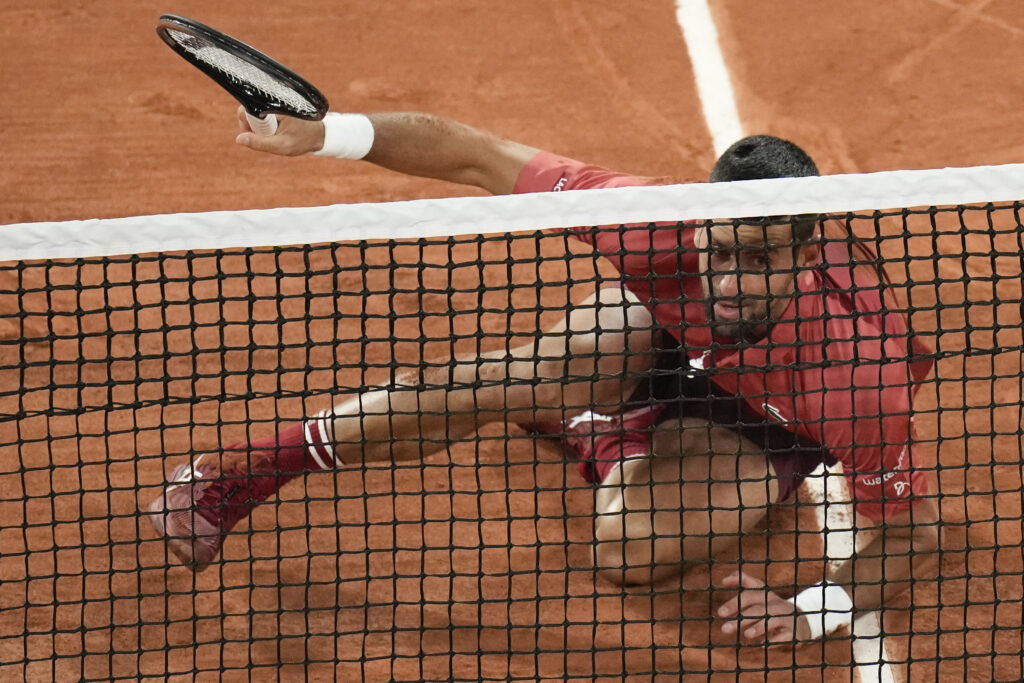 Serbia's Novak Djokovic slips when playing a shot close to the net during his first round match of the French Open tennis tournament against France's Pierre-Hugues Herbert at the Roland Garros stadium in Paris, Tuesday, May 28, 2024. (AP Photo/Christophe Ena)