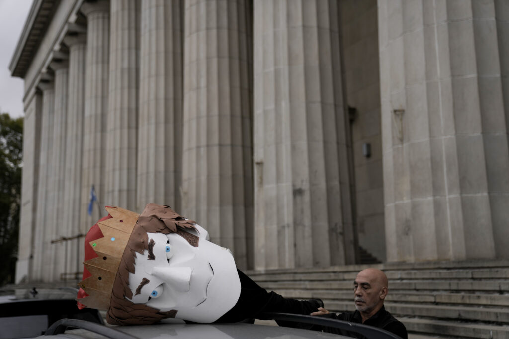 An artist unpacks a crowned puppet head in the likeness of President Javier Milei to take to the International Workers' Day march in Buenos Aires, Argentina, Wednesday, May 1, 2024. (AP Photo/Rodrigo Abd)