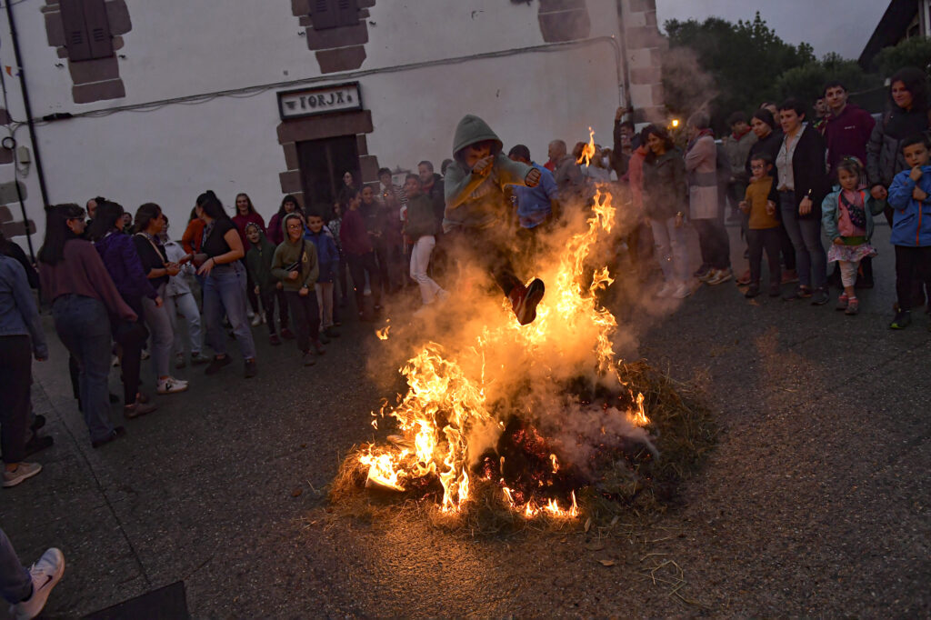 A boy jumps over the fire during the night of San Juan in the Pyrenean village of Arisku, northern Spain, Sunday, June 23, 2024. The night of San Juan, which welcomes the summer season, is an ancient tradition celebrated every year in various towns in Spain. (AP Photo/Alvaro Barrientos)