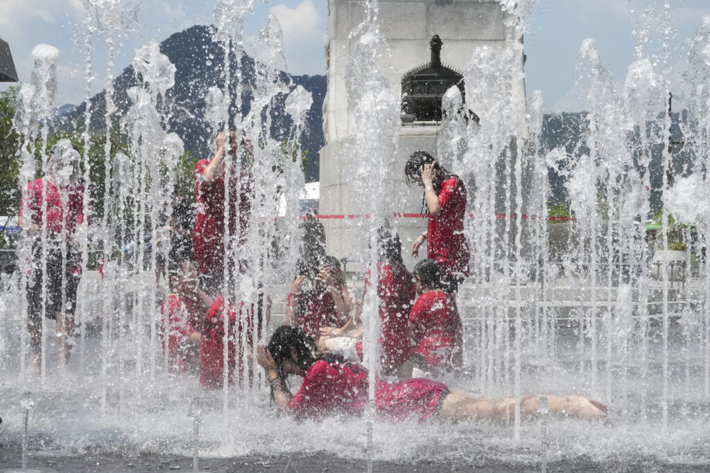 Gangsol elementary school students cool themselves off in a public fountain in Seoul, South Korea, Wednesday, June 26, 2024. South Korean Meteorological Administration forecasted temperatures at 30 degrees Celsius (86 degrees Fahrenheit) in Seoul. (AP Photo/Ahn Young-joon)