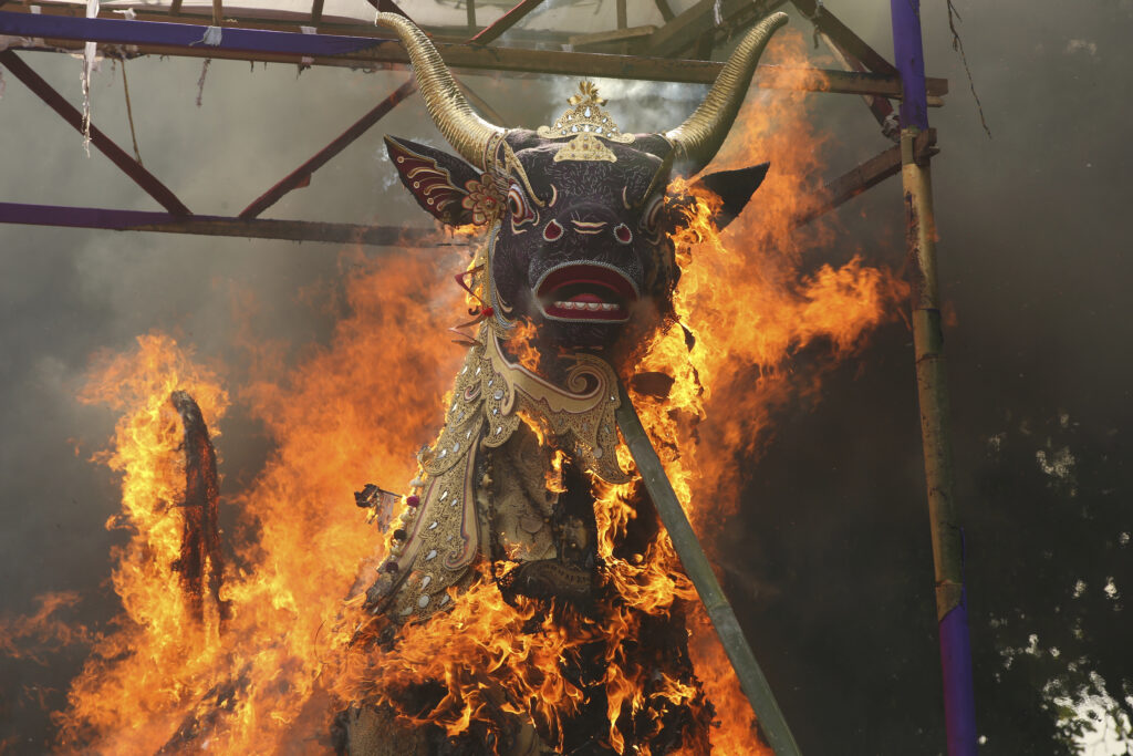 A giant effigy in form of a bull, with the coffin containing the body of Tjokorda Rai Dharmawati, a member of Ubud royal family, is in flames during a Balinese royal cremation ceremony called "pelebon" in Ubud, Bali, Indonesia Monday, June 10, 2024. Thousands of people attended the cremation ceremony for Tjokorda Rai Dharmawati who died in May at the age of 60. (AP Photo/Firdia Lisnawati)
