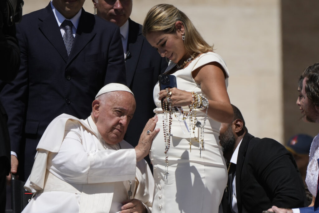 Pope Francis blesses a pregnant woman at the end of his weekly general audience in St. Peter's Square, at the Vatican, Wednesday, June 12, 2024. (AP Photo/Alessandra Tarantino)