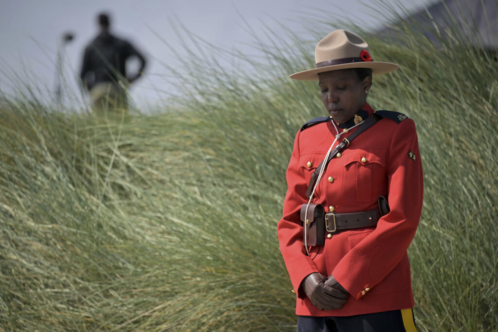 A Canadian Mountie pays her respects during the Canadian commemorative ceremony marking the 80th anniversary of the World War II D-Day landing, at the Juno Beach Centre near Courseulles-sur-Mer, Normandy, Thursday, June 6, 2024. Normandy is hosting various events to officially commemorate the 80th anniversary of the D-Day landings that took place on June 6, 1944. (Lou Benoist, Pool via AP)
