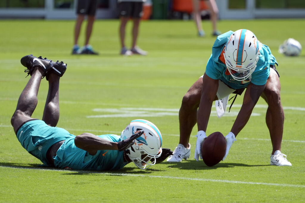 Miami Dolphins Elijah Campbell, right, picks up the ball as Siran Neal is late with the catch during NFL football practice at the team's training facility, Wednesday, June 5, 2024, in Miami Gardens, Fla. (AP Photo/Marta Lavandier)