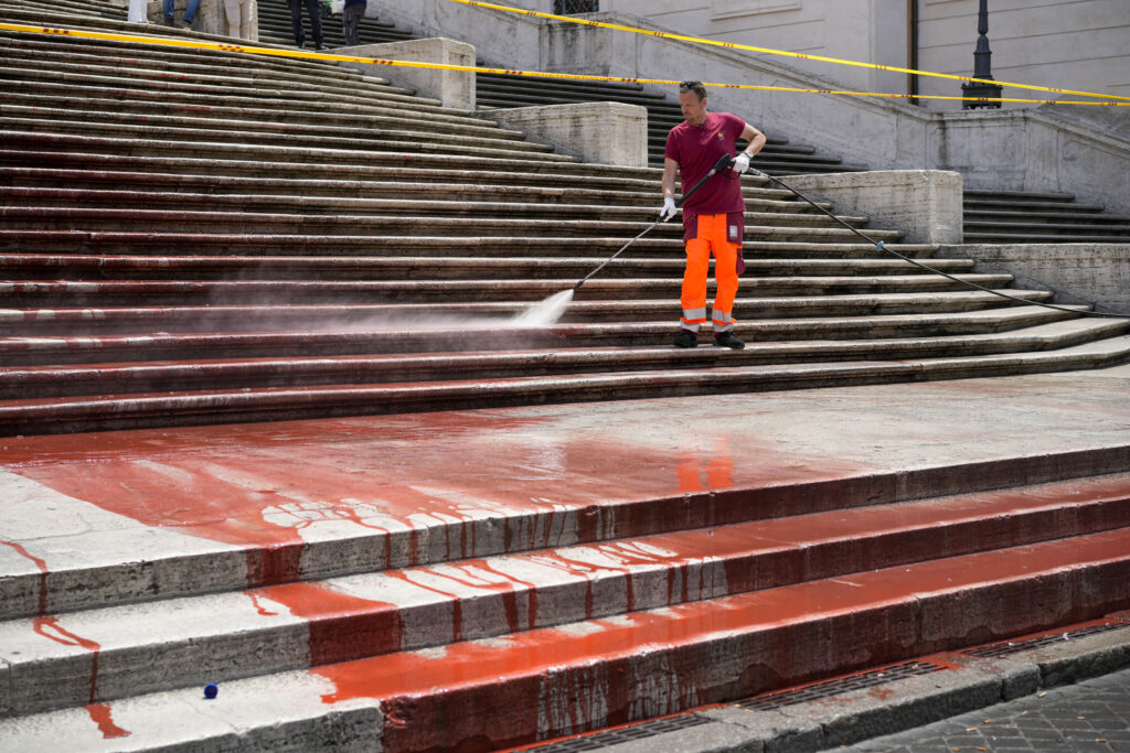 Rome municipality workers clean the Spanish Steps after activists dumped red paint over them protesting violence against women, in Rome, Wednesday, June 26, 2024. (AP Photo/Andrew Medichini)