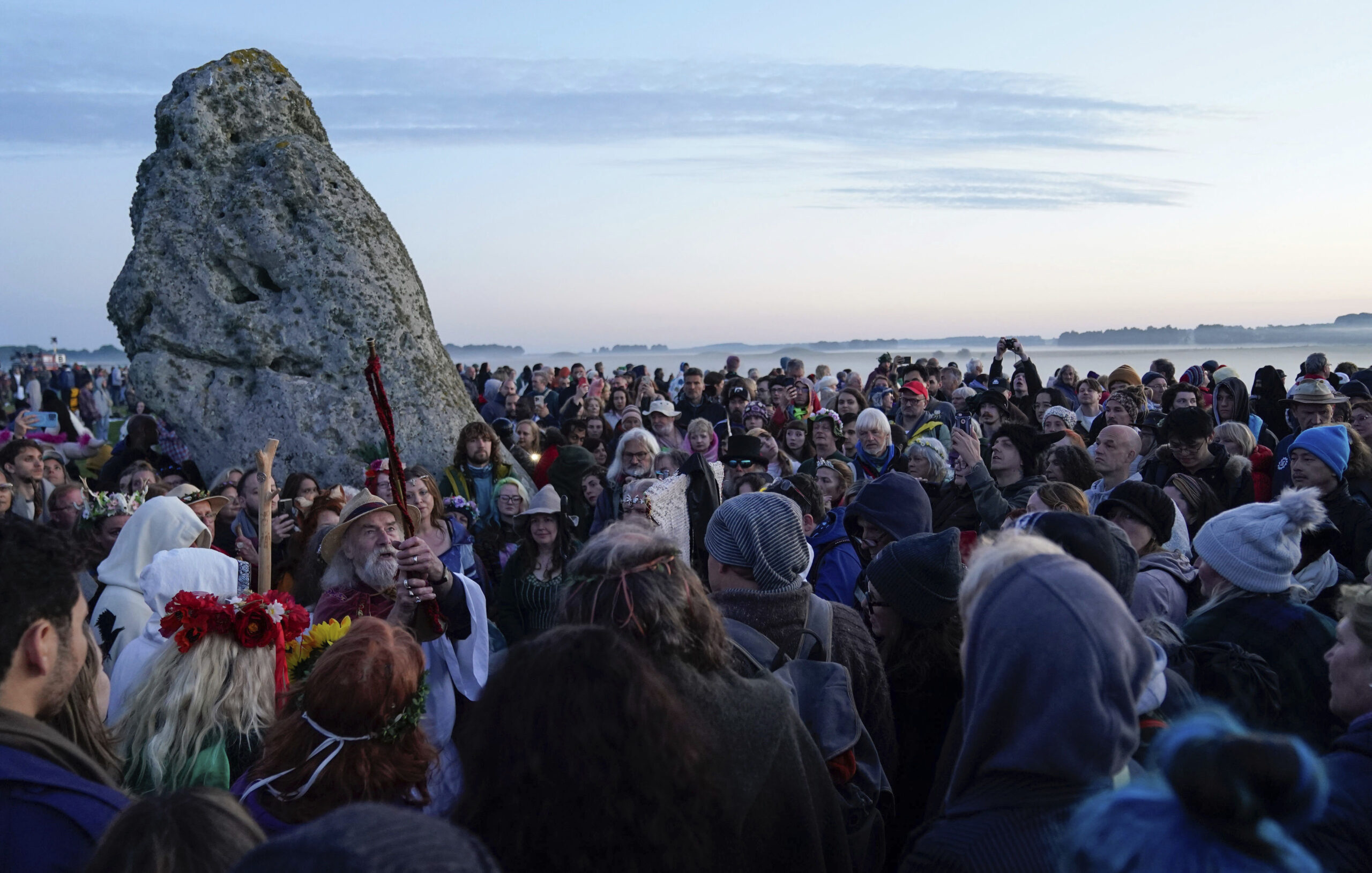 People gather around the Heel Stone ahead of sunrise, as they take part in the Summer Solstice at Stonehenge in Wiltshire, Friday, June 21, 2024. (Andrew Matthews/PA Wire/PA via AP)