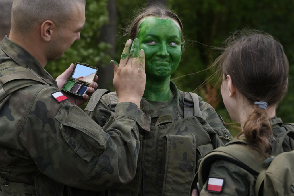 Volunteers in Poland's army learn to apply camouflage face paint during basic training in Nowogrod, Poland, on Thursday June 20, 2024. Poland’s army has launched a program this summer called “Holidays with the Army” to train young volunteers in combat. Nations along NATO’s eastern flank are strengthening their defenses while fearing that Russia could one day attack them if it prevails in neighboring Ukraine. (AP Photo/Czarek Sokolowski)