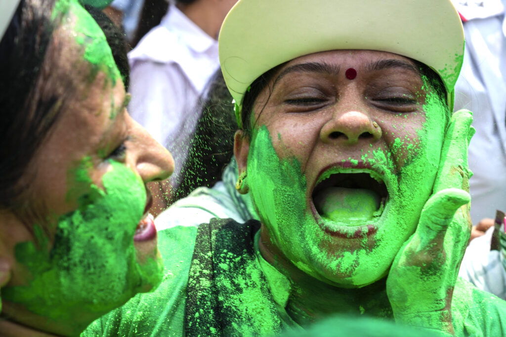 Faces of Trinamool Congress Party supporters smeared with green colour celebrate the election results in Kolkata, India, Tuesday, June 4, 2024. Prime Minister Narendra Modi's Hindu nationalist party showed a comfortable lead Tuesday, according to early figures reported by India's Election Commission, but was facing a stronger challenge from the opposition than had been expected. (AP Photo/Bikas Das)