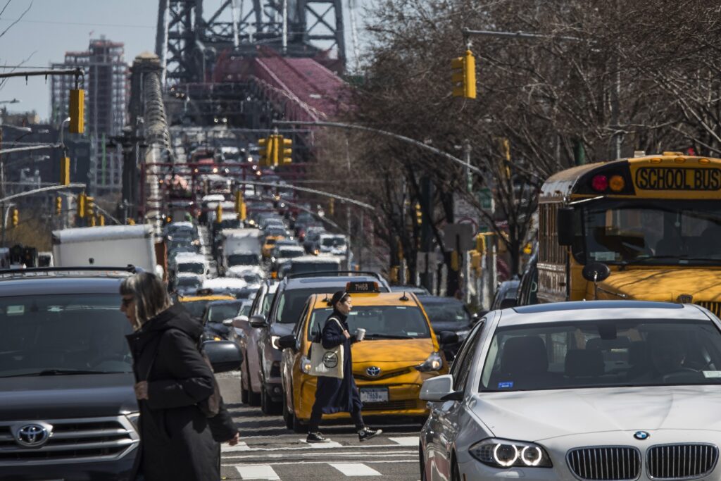 Pedestrians cross Delancey Street as congested traffic from Brooklyn enters Manhattan over the Williamsburg Bridge, March 28, 2019, in New York. AP Photo/Mary Altaffer, File