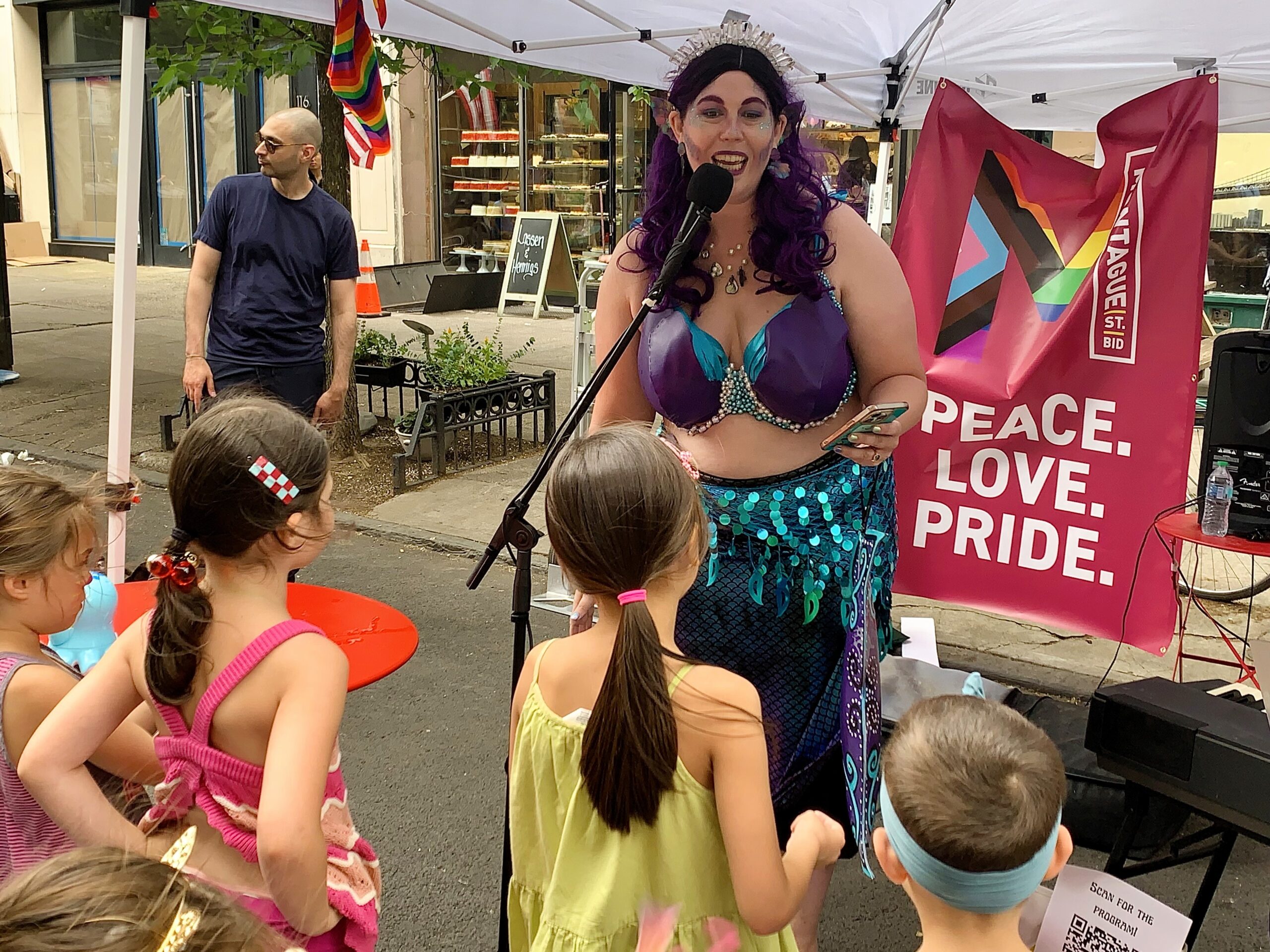 Buoy, Brooklyn's opera-singing Mermaid, accompanied by Capt. Emma on the piano (not shown), captivated youngsters on Montague Street on Sunday during the Montague BID’s Pride celebration.
