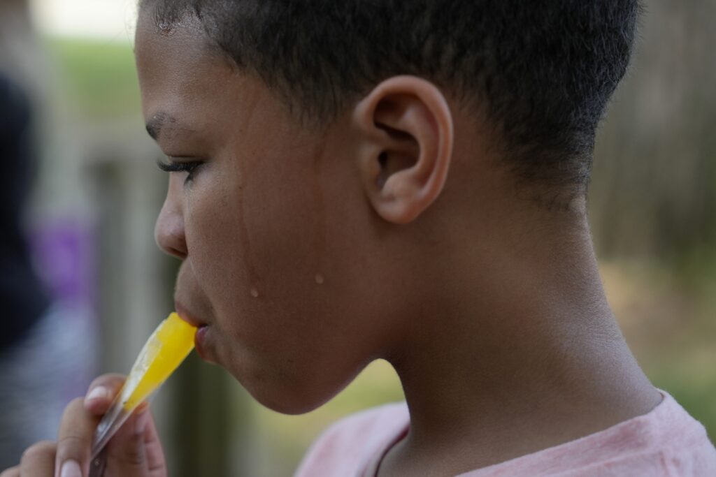 Zariah Fields eats a popsicle, Thursday, June 20, 2024, at YMCA Camp Kern in Oregonia, Ohio. As the first heat wave of the season ripples across the U.S., summer camps are working to keep their children cool while still letting the kids enjoy being outside with nature. (AP Photo/Joshua A. Bickel)
