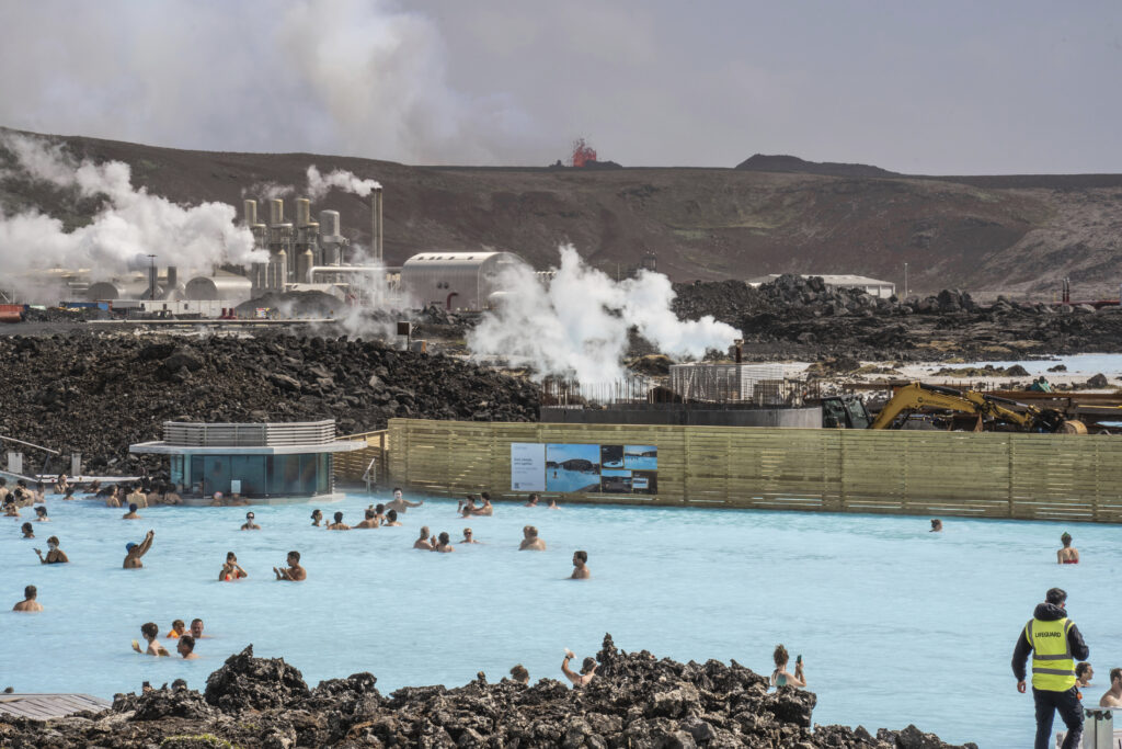 The Blue Lagoon with people bathing in it as the volcanic crater spews lava in the background in Grindavik, Iceland, Sunday, June 2, 2024. The popular Blue Lagoon geothermal spa, one of Iceland’s biggest tourist attractions in the country's southwest, was reopened Sunday after authorities said a nearby volcano had stabilized after erupting four days earlier. (AP Photo/Marco di Marco)