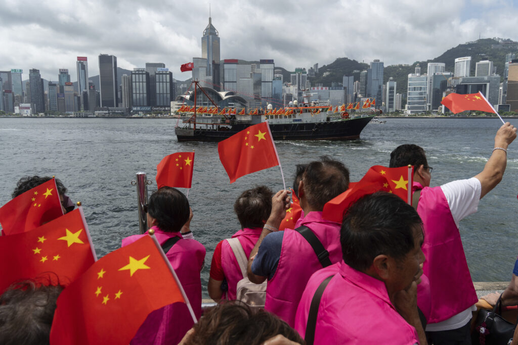 Pro-Beijing supporters hold Chinese flags to mark the 27th anniversary of Hong Kong's return to Chinese rule in Hong Kong, Monday, July 1, 2024. (AP Photo/Chan Long Hei)