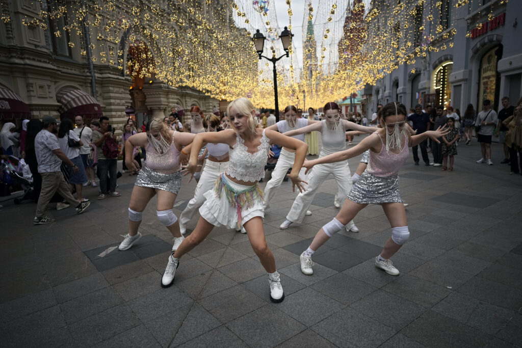 Young Russian women dance to the music of Soojin on the pedestrian of Nikolskaya street near Red Square and the Kremlin in Moscow, Russia, Thursday, July 18, 2024. Seo Soo-jin, better known mononymously as Soojin, is a South Korean singer, dancer, and rapper, who has many fans in Russia. (AP Photo/Alexander Zemlianichenko)