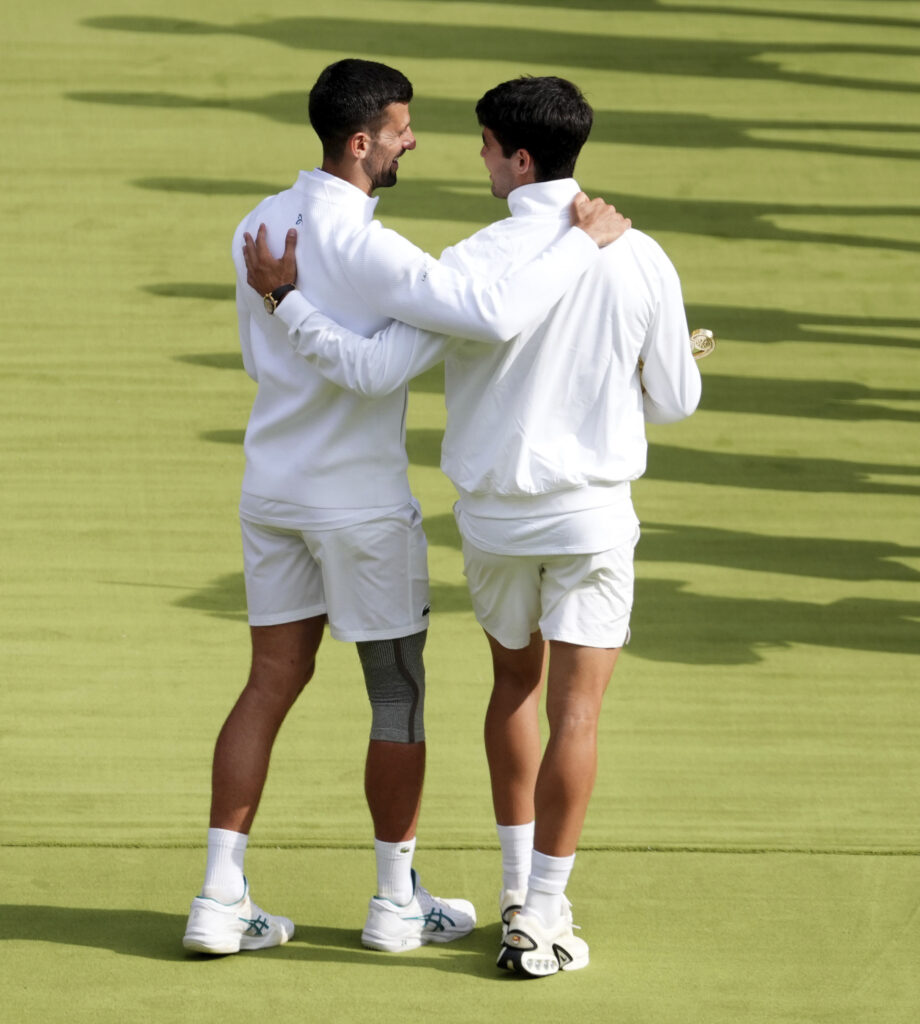 Carlos Alcaraz speaks with Novak Djokovic at the Wimbledon tennis championships in, Sunday, July 14, 2024. (John Walton/PA via AP)