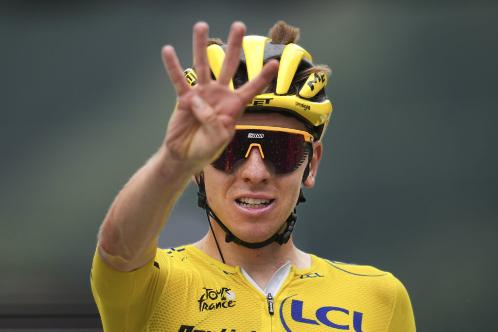 Slovenia's Tadej Pogacar, wearing the overall leader's yellow jersey, flashes four finger for his fourth stage win during the nineteenth stage of the Tour de France cycling race over 144.6 kilometers (89.9 miles) with start in Embrun and finish in Isola 2000, France, Friday, July 19, 2024. (AP Photo/Daniel Cole)