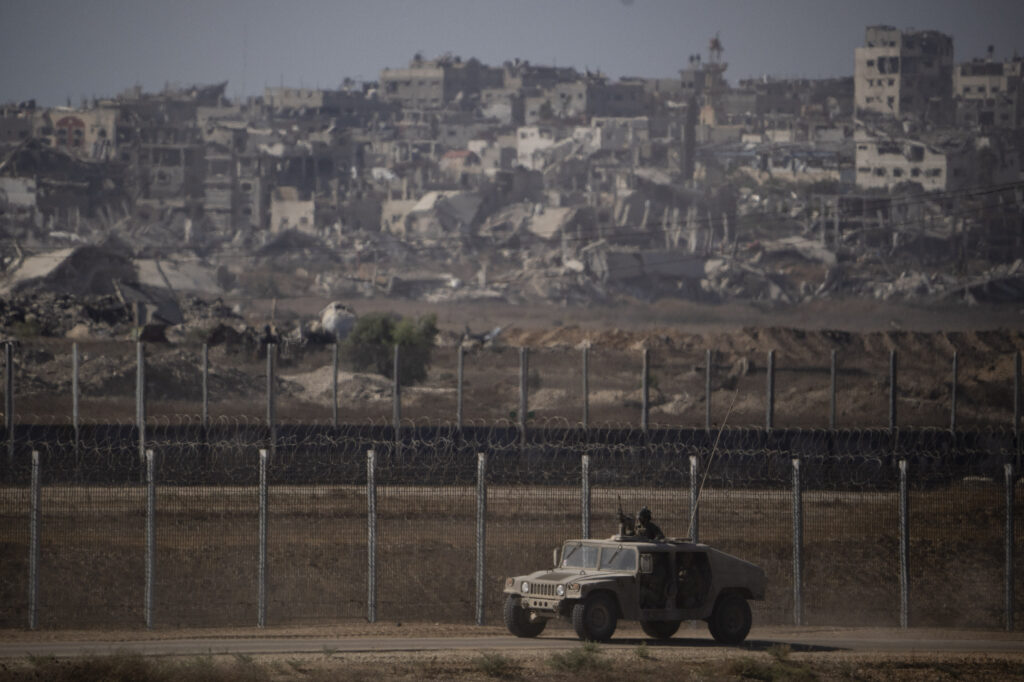 Israeli soldiers move near the Israeli-Gaza border, as seen from southern Israel, Monday, July 8, 2024. Israeli forces advanced deeper into the Gaza Strip's largest city in pursuit of militants who had regrouped there, sending thousands of Palestinians fleeing on Monday from an area ravaged in the early weeks of the nine-month-long war. (AP Photo/Leo Correa)